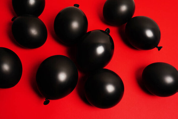 Black balloons on red background. background birthday or other holiday