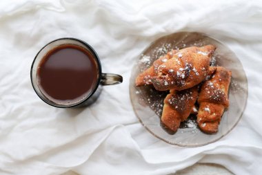 Beyaz arka planda ev yapımı kruvasan ile sıcak kahve fincanı.