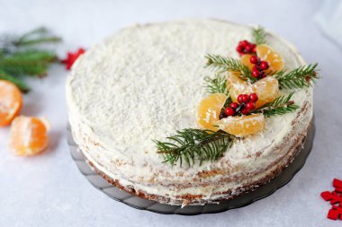 Noel meyveli pasta, kaplanmış kış yeşilliği, dekoratif böğürtlen ve mandalina