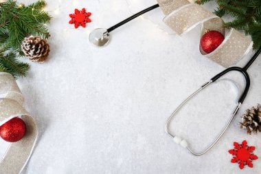 Tıbbi Noel ve yeni yıl. Beyaz zemin üzerinde stetoskop ve kırmızı noel süslemeleri kopyalama alanı ile