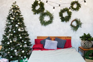 Yılbaşı arifesi. Yastıklı Noel ağacı yatağın yanında. Mutlu Noel kavramları