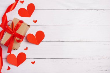 Sevgililer Günü hediye kutusu, beyaz ahşap arka planda kalpler ve kurdele, kopyalama alanı
