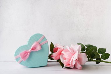 Romantic valentine background with gift box heart shape and Pink roses on white background, copy space