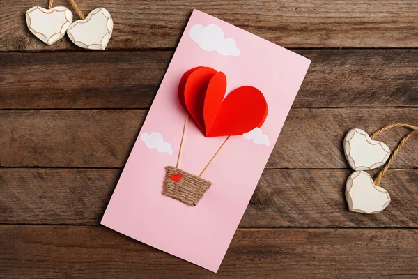 木制背景的带红心降落伞的情人节手工贺卡 — 图库照片