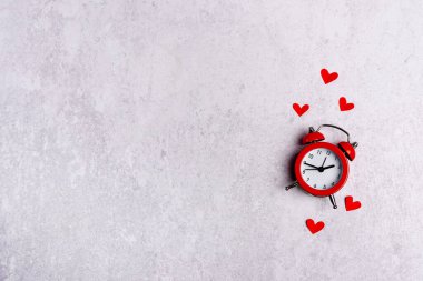 Gri zemin üzerinde kalpler ve kopyalama alanı olan parlak kırmızı alarm saati