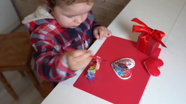 小さな子供の女の子は絵具で手作りのバレンタインハートを飾ります 子供のDiy 趣味のコンセプト あなた自身の手で贈り物 バレンタインデーの装飾 — ストック動画