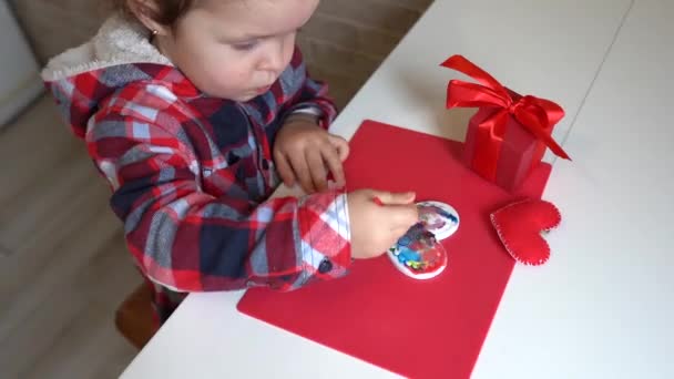 小女孩用油漆装饰手工制作的瓦伦丁心脏 孩子们的Diy 业余爱好的概念 礼物用你自己的手 情人节装饰品 — 图库视频影像