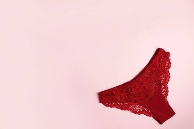 Pembe arkaplanda dantelli kırmızı külot ve kopyalama alanı