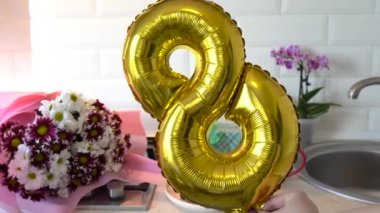 Altın balon 8 8 ve bahar çiçekleri mutfak masasında hediye kutusu ve kahvaltılı. Anneler Günü. 8 Mart, Uluslararası Kadınlar Günü