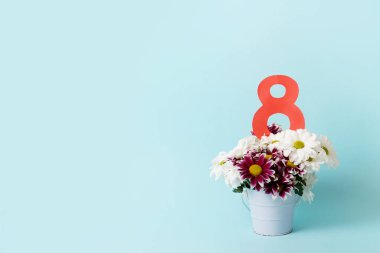 8 numara, mavi arkaplanda bir buket çiçek ve fotokopi alanı. Kadınlar için bahar kartı