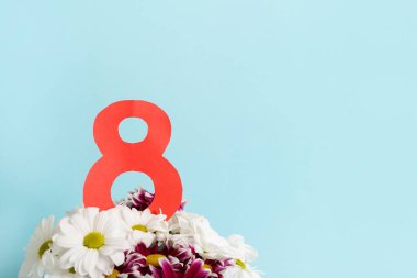 8 numara, mavi arkaplanda bir buket çiçek ve fotokopi alanı. Kadınlar için bahar kartı