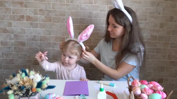 迷人的年轻女子和可爱的小女孩正准备庆祝复活节 妈妈和女儿都戴着兔子耳朵在家里玩得很开心 — 图库视频影像