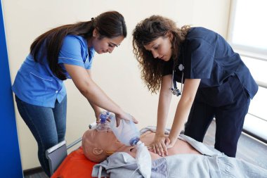 Nursing students are learning how to rescue the patients in emergency. CPR training with CPR doll. clipart