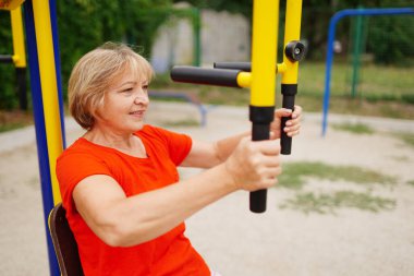 58 yaşında, dışarıda egzersiz yapan güzel, sağlıklı bir kadın.