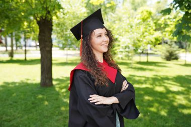 Üniversitenin yakınlarında açık havada şapka takan başarılı bir kız öğrencinin portresi.