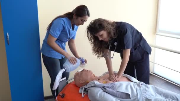 看護学生は緊急時に患者を救助する方法を学んでいます Cpr人形とCprトレーニング — ストック動画