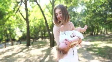 Mutlu anne ve bebeği parkta eğleniyor.