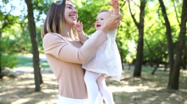 Parkta baloncuklar çıkaran mutlu anne ve kız