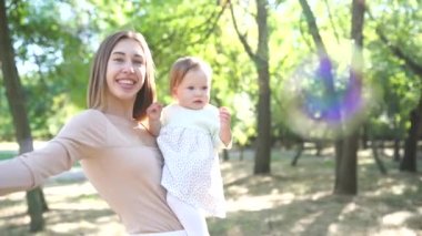 Parkta baloncuklar çıkaran mutlu anne ve kız