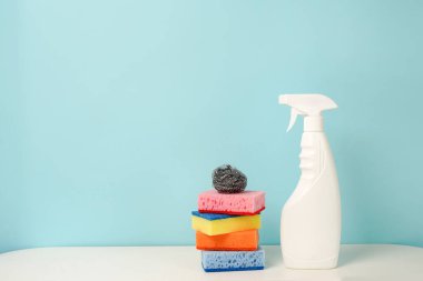 Beyaz şişe temizleme procuct ve süngerler mavi arkaplan üzerinde boş alan metin için