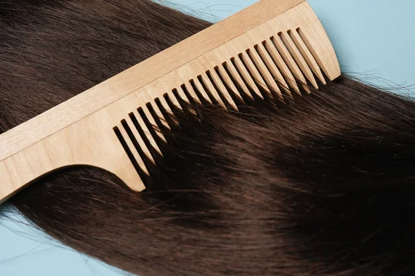 Lunghi Capelli Castani Naturale Spazzola Capelli Legno Sfondo Blu — Foto Stock