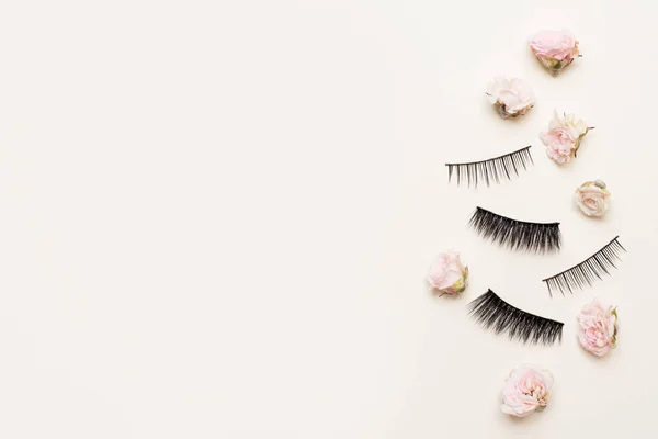 Composition Different Types False Eyelashes White Background Small Pink Flowers — Stock Photo, Image