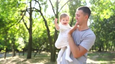 Mutlu genç baba, küçük kızıyla dışarıda vakit geçiriyor.