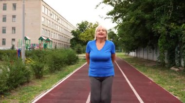 64 yaşında, dışarıda egzersiz yapan güzel, sağlıklı bir kadın.