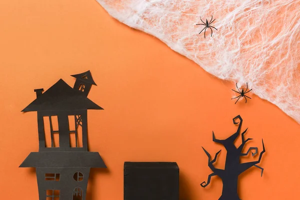 Halloween podiums or pedestal for product display, black house and tree with spiderweb on orange background. Halloween holiday decorations.