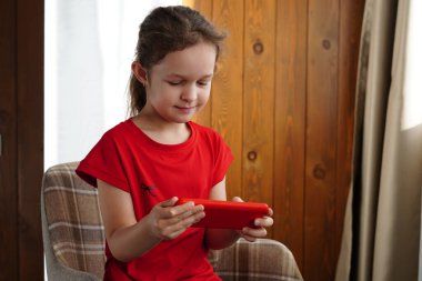 Küçük Kız Sandalyede Otururken Akıllı Telefon Kullanıyor