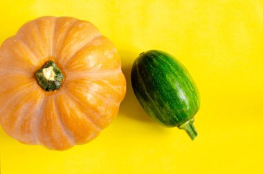 Turuncu arka planda iki balkabağı. Tek renkli pankart, fotokopi alanı olan poster. Cadılar Bayramı, Şükran Günü ya da sonbahar hasat konsepti. Sonbahar doğası, kırmızı kabak. Reklam için şablon, mevsimlik satış