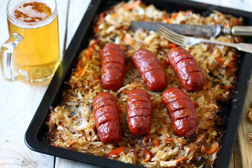 A glass of beer and sausages with sauerkraut. Oktoberfest theme. German beer with snacks.