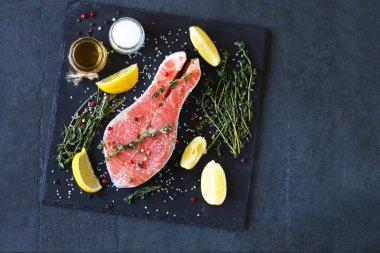 Taş bir tahtanın üzerinde otlu ve baharatlı tuzlu somon. Balık sunumu.