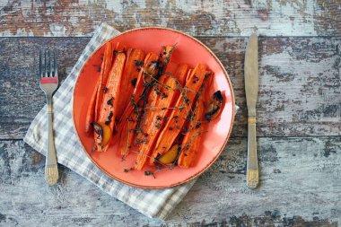 Fırında havuç tabağı. Makro. Baharatlı ve otlu şeritli fırında havuç. Vejetaryen diyeti. Vejetaryen yemek tarifi.