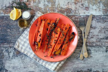 Fırında havuç tabağı. Makro. Baharatlı ve otlu şeritli fırında havuç. Vejetaryen diyeti. Vejetaryen yemek tarifi.