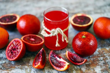 Bir bardak taze kırmızı portakal suyu. Kırmızı portakallar.