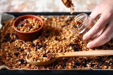 Kavanozda ve tavada ev yapımı granola. Sağlıklı kahvaltı ya da atıştırmalık. Evde yemek pişirmek..