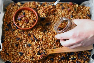 Kavanozda ve tavada ev yapımı granola. Sağlıklı kahvaltı ya da atıştırmalık. Evde yemek pişirmek..