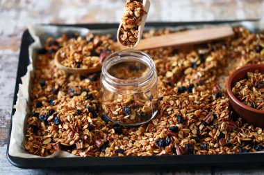 Kavanozda ve tavada ev yapımı granola. Sağlıklı kahvaltı ya da atıştırmalık. Evde yemek pişirmek..