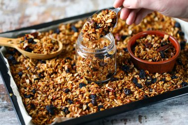 Kavanozda ve tavada ev yapımı granola. Sağlıklı kahvaltı ya da atıştırmalık. Evde yemek pişirmek..