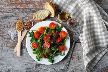 Arugula, vişneli domates ve çekirdekli sağlıklı salata..