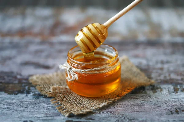 Kavanozda bal. Bal için sopa. Sağlıklı tatlılık. Arıcılık ürünü.