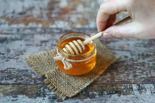 Fresh honey. Jar of flower honey. Stick for honey.