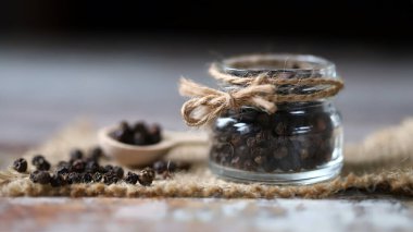 Karabiber. Kavanozda karabiber ve tahta kaşık..