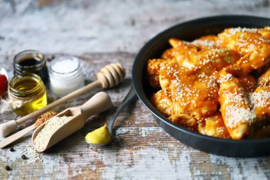 Susam sosunda marine edilmiş çiğ tavuk kanadı..