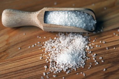 Tahta bir spatulada öğütülmüş beyaz deniz kristal tuzu..