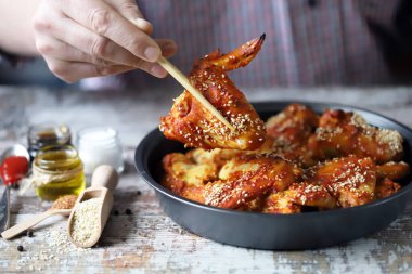 Adam tavuk kanadı yiyor. Kızarmış tavuk kanadı..