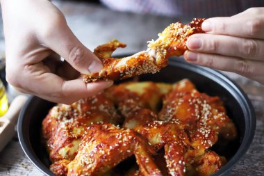 Adam tavuk kanadı yiyor. Kızarmış tavuk kanadı..