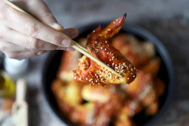 Adam tavuk kanadı yiyor. Kızarmış tavuk kanadı..