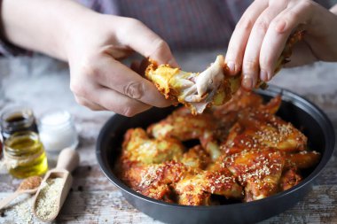 Adam tavuk kanadı yiyor. Kızarmış tavuk kanadı..